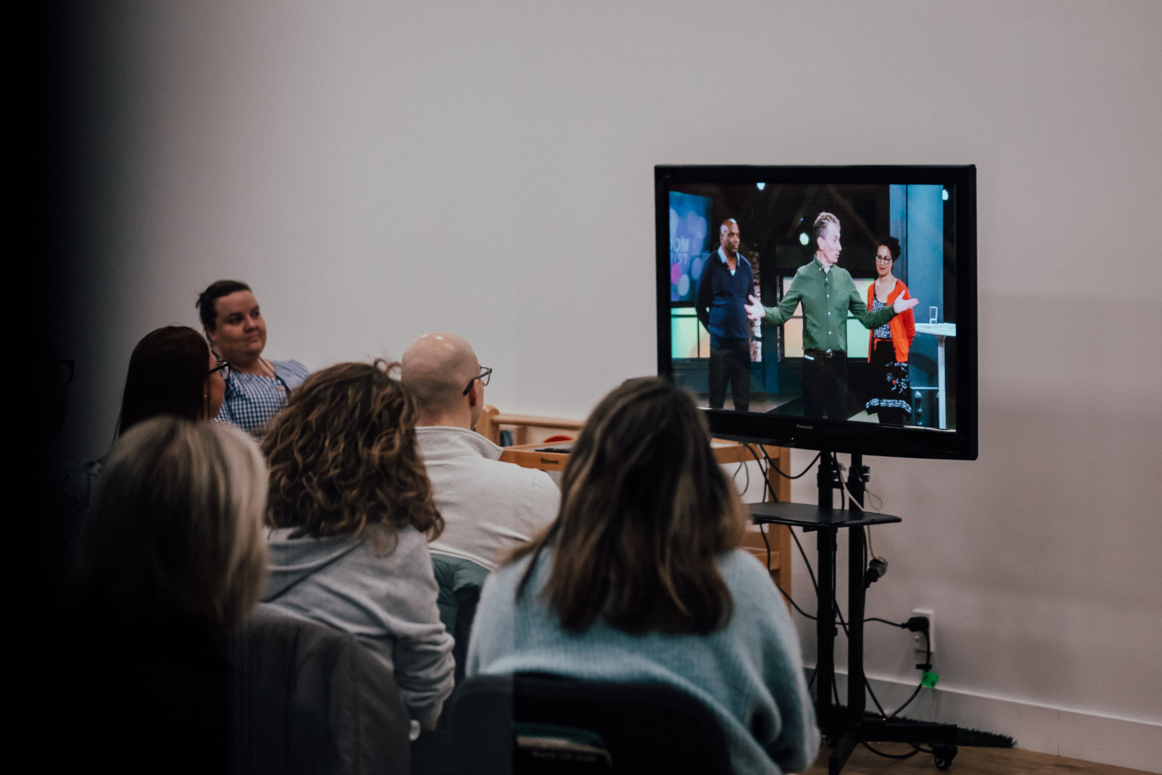 People in a Night School course watching course material on TV